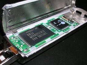 Chip de uma EEPROM - Memória Flash (O chip maior é a memória flash) Chip de uma EEPROM - Memória Flash (O chip maior é a memória flash)