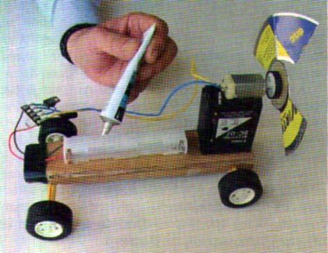 Colando o suporte de pilhas.Note como foi colado o motor sobre um cartucho de tinta vazio. Colando o suporte de pilhas.Note como foi colado o motor sobre um cartucho de tinta vazio.